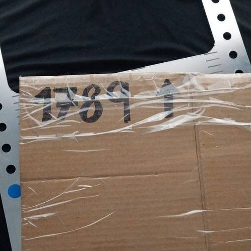Aluminum plate beside cardboard packaging