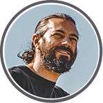 JS-headshot-150p Circular profile image of man with scruffy beard and long hair pulled back