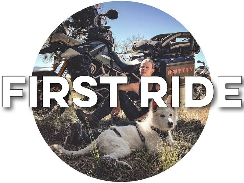 Woman sitting beside motorcycle with white dog in the tall grass with overlaid text "FIRST RIDE"