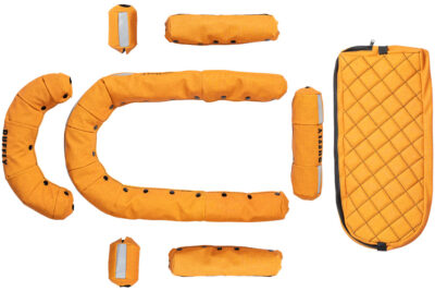 Organized layout of snap-on replacement upholstery in orange vinyl with black stitching for motorcycle dog carrier
