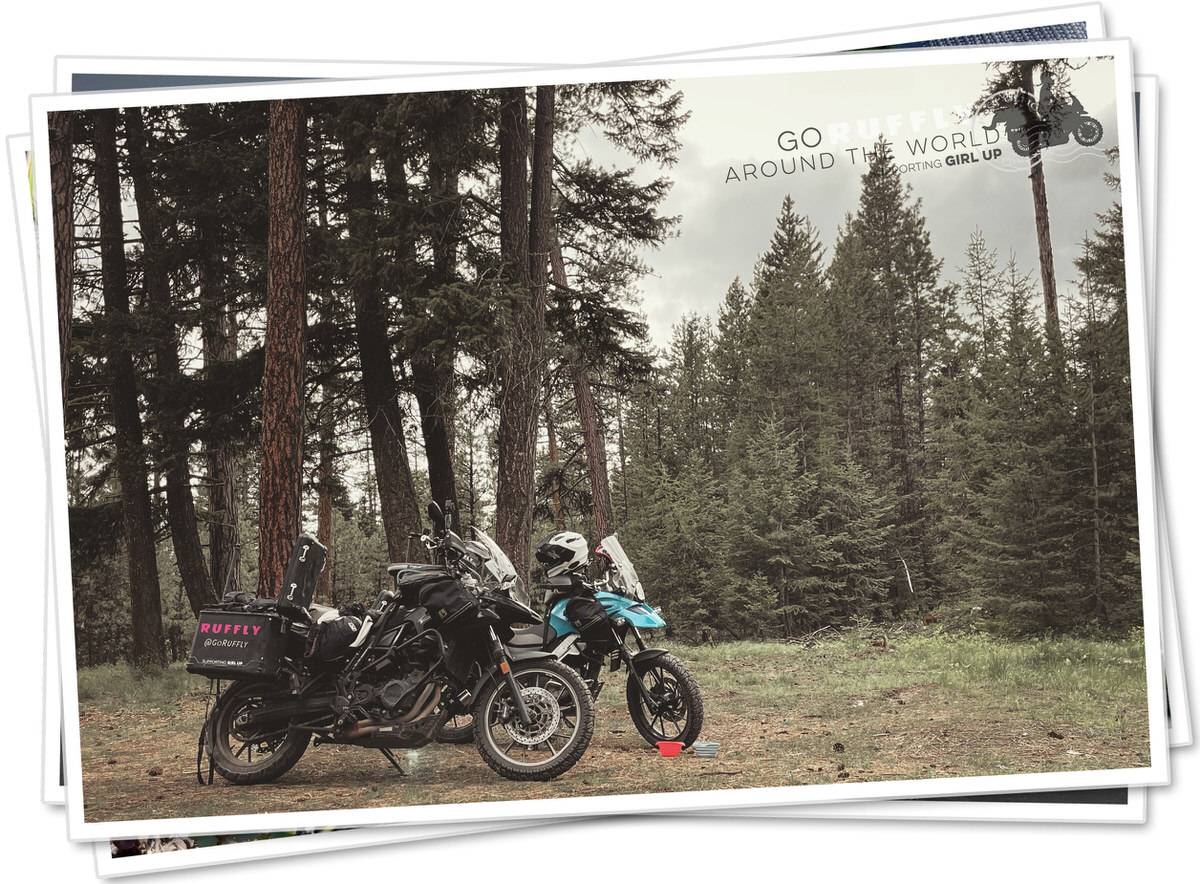 Postcard of two adventure motorcycles park in a forest